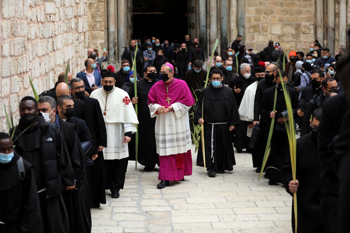 Latin Patriarch of Jerusalem Pierbattista Pizzaballa walks along with Christian worshippers and the clergy holding palm fronds during a Palm Sunday procession outside the Church of the Holy Sepulchre in Jerusalem. [Ammar Awad/Reuters]