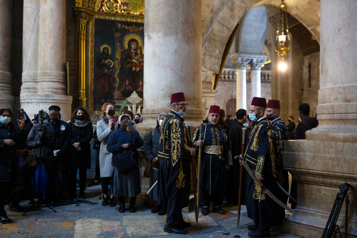 Worshippers attend Palm Sunday mass in the Church of the Holy Sepulchre in the Old City of Jerusalem. [Maya Alleruzzo/AP Photo]