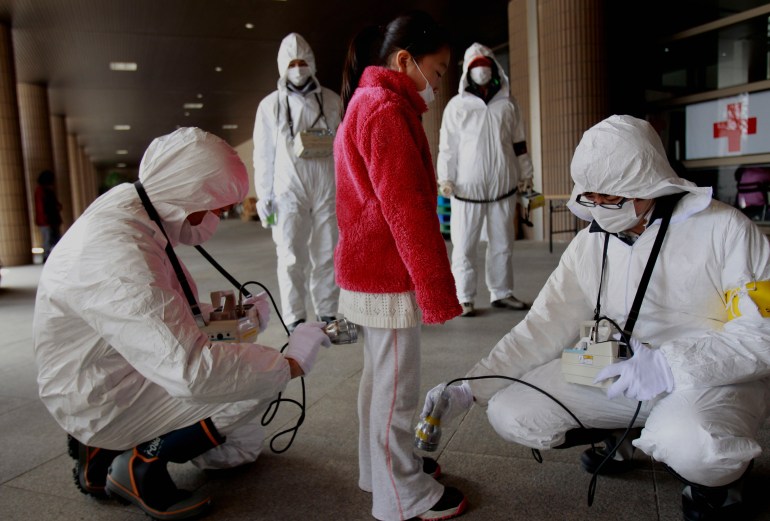 a young evacuee is screened at a shelter for leaked radiation from the damaged Fukushima nuclear plant in Fukushima, Japan