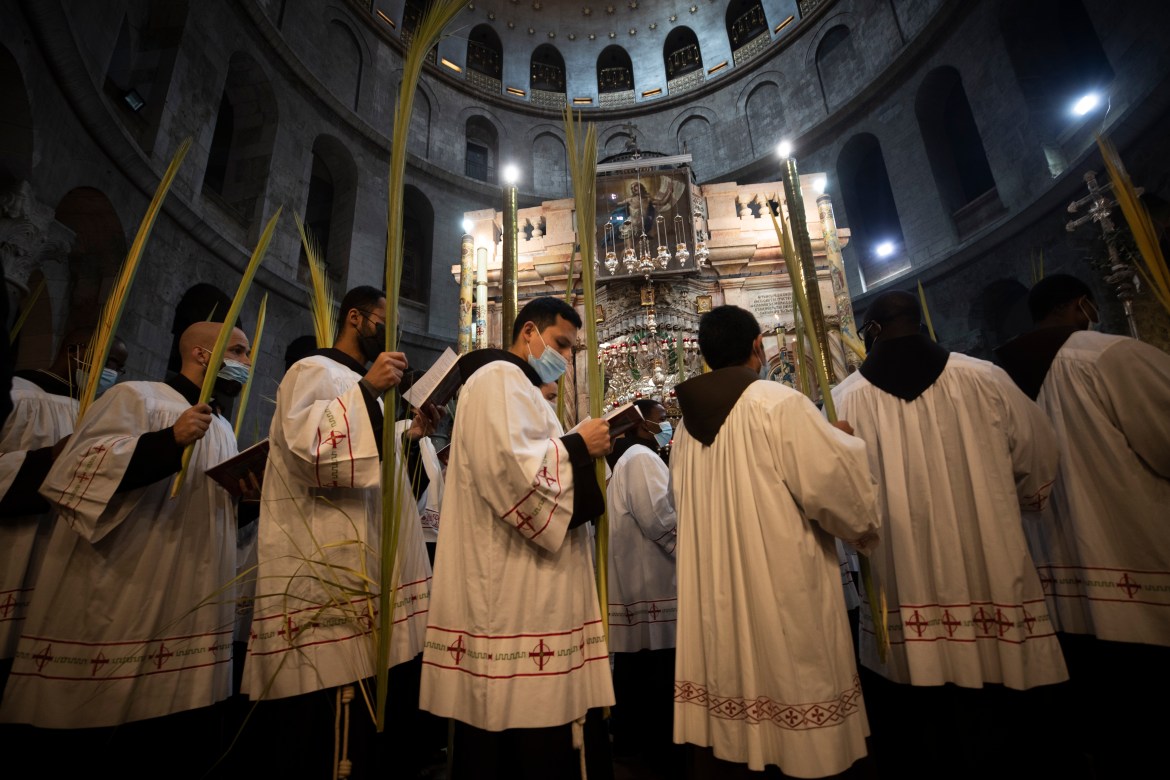 Christian clergymen take part in the Palm Sunday Mass in the Church of the Holy Sepulchre. [Atef Safadi/EPA]