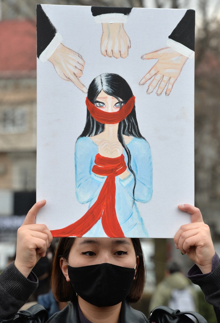 A woman holds a poster at a rally