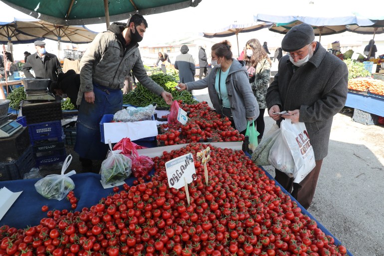 People wearing protective masks shop at a local market in Ankara [File: Adem Altan/AFP]
