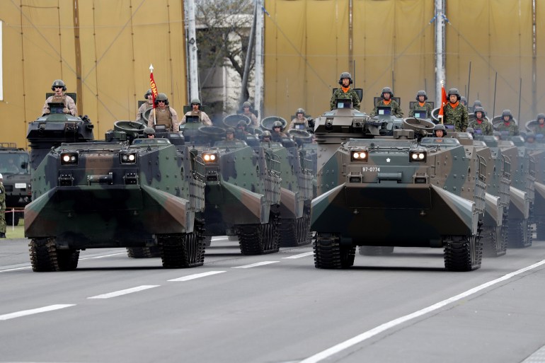 The US Army, left, and the Japanese Self-Defence Forces (SDF) military vehicles parade during a ceremony at a Japanese base north of Tokyo in 2018 [File: Kim Kyung-Hoon/Reuters]