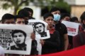 Relatives of Mexican missing students hold posters with their images