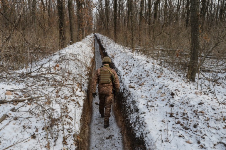 A Ukrainian service member walks along fighting positions on the contact line with Russian-backed separatist rebels near the town of Avdiivka in Donetsk Region, Ukraine