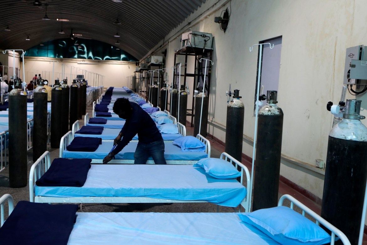 A worker cleans a newly set up COVID- 19 hospital at the Science Centre in Mumbai. [Rajanish Kakade/AP Photo]