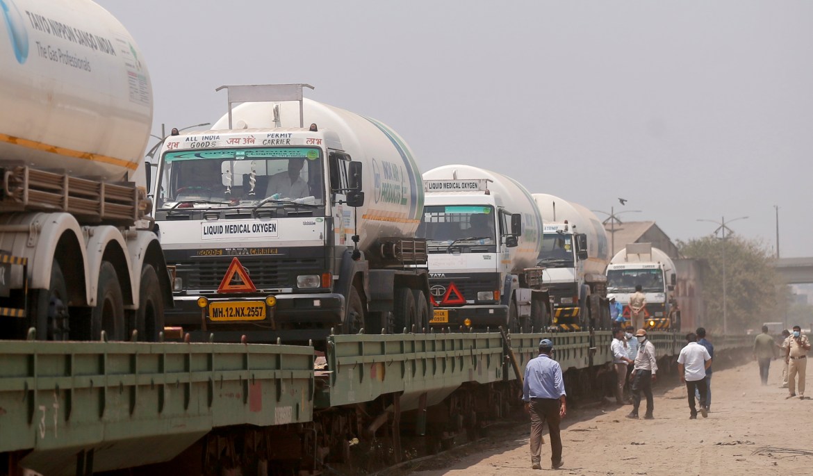 Empty tankers are loaded on a train wagon at the Kalamboli goods yard in Navi Mumbai, Maharashtra state, before they are transported to collect liquid medical oxygen from other states. The western state, which is worst hit by the coronavirus is facing a shortage of the gas used for the treatment of COVID-19 patients. [Rafiq Maqbool/AP Photo]