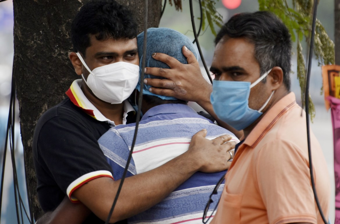 Члены семьи пациента с COVID-19, скончавшегося в государственной больнице в Калькутте.  [Индранил Адитья / NurPhoto через Getty Images]