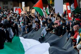 People chant and wave a giant Palestinian flag as thousands gather in Toronto, Ontario, Canada to show their support for the people of Palestine, on May 15, 2021 [Cole Burston/AFP]