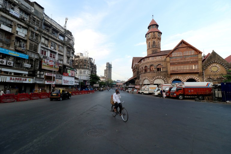 Man on bike in deserted street in Mumbai