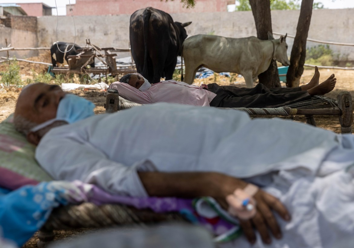 Villagers with breathing difficulties rest in cots as they receive treatment at the makeshift open-air clinic. [Danish Siddiqui/Reuters]