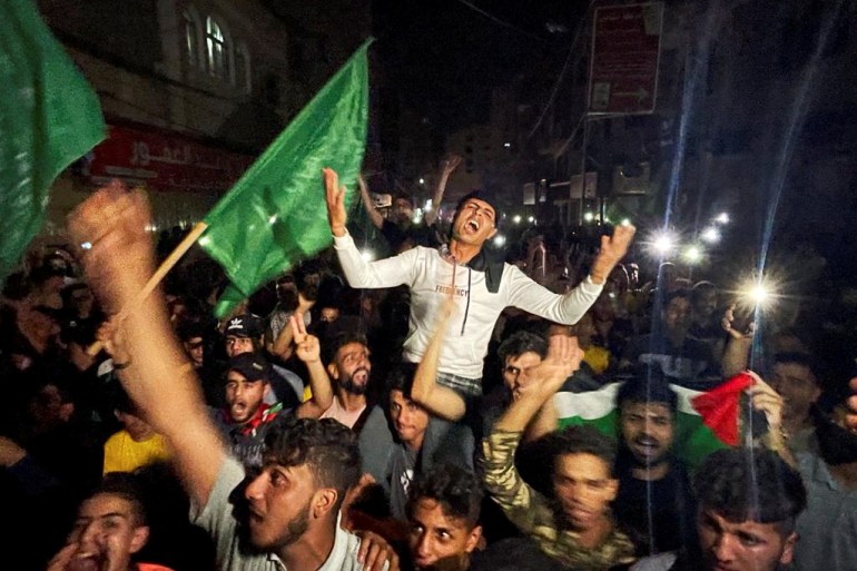 Palestinians celebrate in southern Gaza after the ceasefire came into effect [Ibraheem Abu Mustafa/AFP]