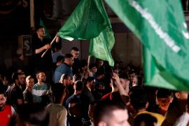 Palestinians wave green Hamas flags while celebrating the cease-fire agreement between Israel and Hamas in Gaza City