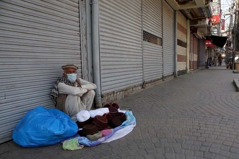 A street vendor waits for customers at a market closed due to COVID-19 measures in Peshawar, Pakistan