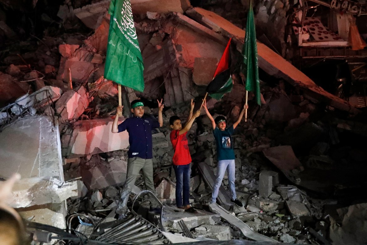 Young men waved Palestinian and Hamas flags, passed out sweets, honked horns and set off fireworks. [Adel Hana/AP Photo]