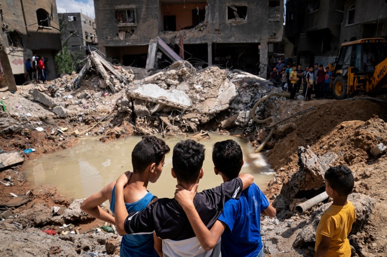 Children in Gaza look at a destroyed home.