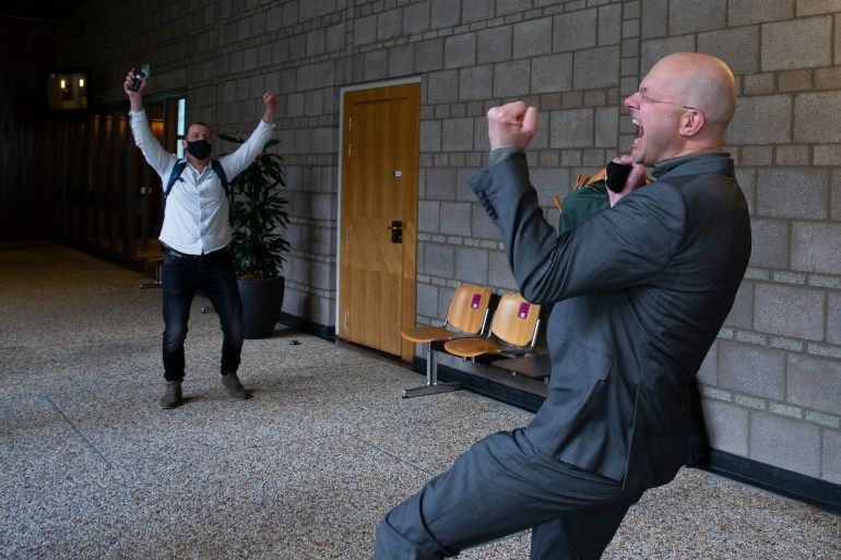 Milieudefensie director Donald Pols, right, celebrates the outcome of the verdict in the court case of Milieudefensie, the Dutch arm of the Friends of the Earth environmental organisation, against Royal Dutch Shell in The Hague, the Netherlands on Wednesday [Peter Dejong/AP]