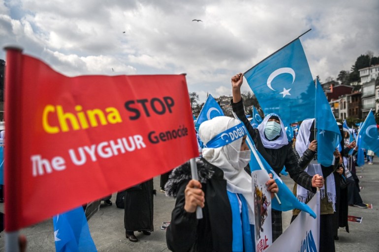 Members of Women Muslim Uighur minority hold placards and flags