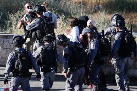 Israel security forces push away Palestinian activists.