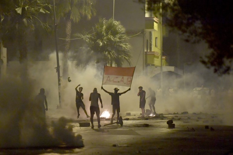 Tunisian security forces fire tear gas in the Sidi Hassine suburb of Tunis [Fethi Belaid/AFP]