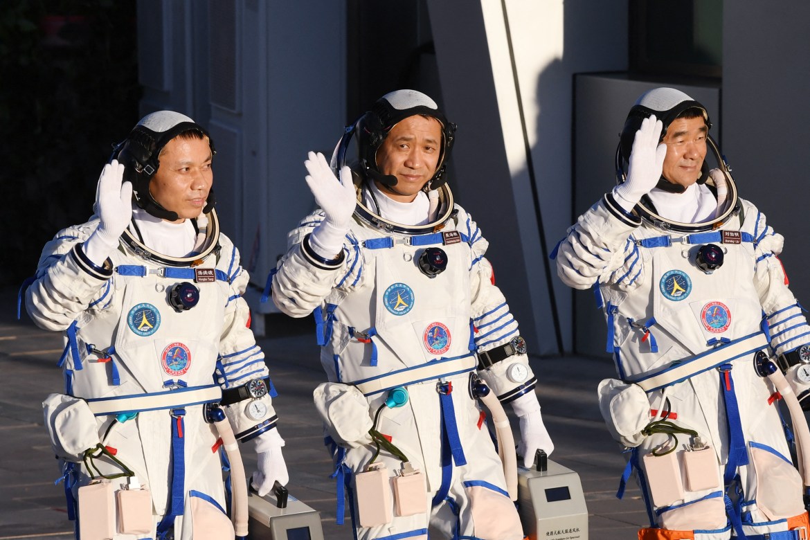 Astronauts Tang Hongbo, left, Nie Haisheng, centre, and Liu Boming wave during a departure ceremony before boarding the Shenzhou-12 spacecraft on a Long March-2F carrier rocket at the Jiuquan Satellite Launch Centre in the Gobi desert in northwest China. [Greg Baker/AFP]