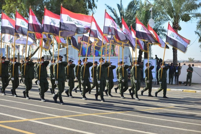 Los miembros de las Fuerzas de Movilización Popular respaldadas por Irán, o Hashd al-Shaabi, participan en un desfile para celebrar el séptimo aniversario de su fundación en el Campamento Ashraf en Khalis, en la provincia de Diyala, el 26 de junio [Hashd al-Shaabi Media vía AFP]