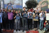 Palestinians hold posters depicting human rights activist Nizar Banat during a protest triggered by the violent arrest and death in custody of Banat, in his hometown of Hebron in the occupied West Bank, on June 27, 2021. [Mosab Shawer/AFP]