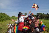 People waving Ugandan and rainbow flags take part in the Gay Pride parade in Entebbe on August 8, 2015 [File: AFP/Isaac Kasamani]