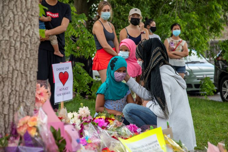 Kira Stephani speaks with her daughters Aisha Sayyed (front) and Aliyah Sayyed at a makeshift memorial for the Muslim family killed in London, Ontario, in 2021