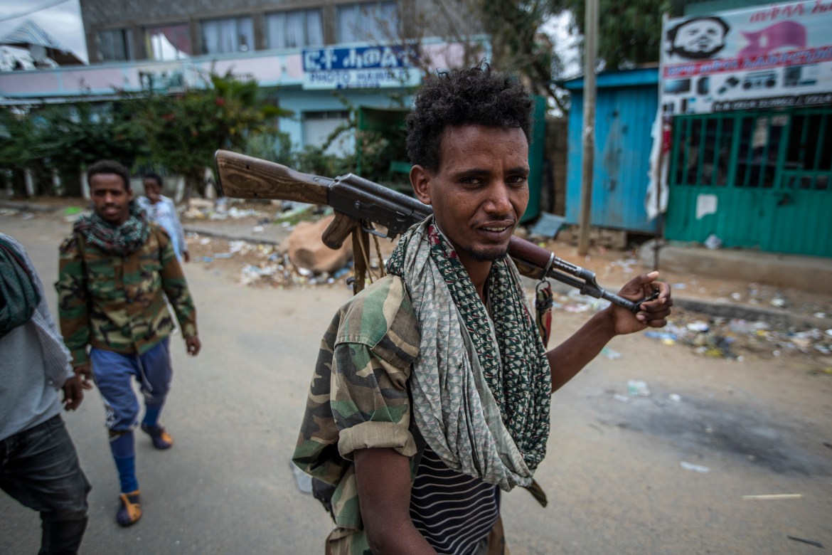 Fighters loyal to the Tigray People's Liberation Front (TPLF) walk along a street in the town of Hawzen, in the Tigray region of northern Ethiopia. [Ben Curtis/AP Photo]