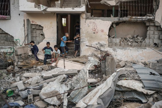 Palestinian children play among the rubble of homes destroyed by airstrikes