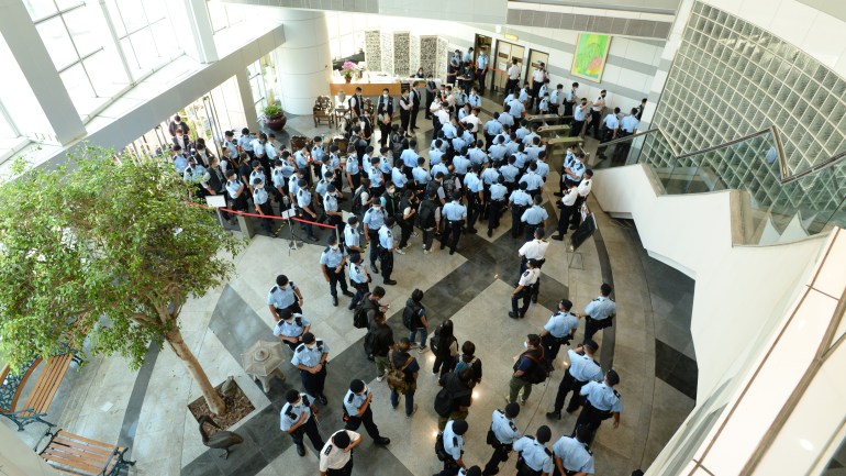 Police officers arriving at the office of Next Media, publisher of Apple Daily, in Hong Kong, China, 17 June 2021.