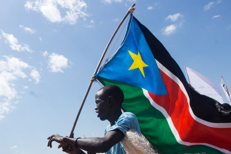 A man carries the South Sudan's national flag at a camp for displaced persons in Juba.