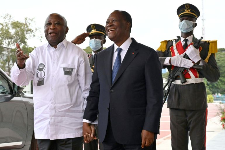 Ivory Coast President Alassane Ouattara (C) poses with former President Laurent Gbagbo (L) at the presidential palace in Abidjan