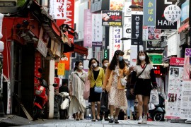 Women shoppers walk down a street in Seoul, South Korea