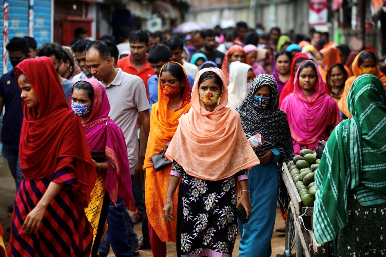 Garment workers come out of a factory during the lunch break as factories remain open despite a countrywide lockdown, in Dhaka, Bangladesh