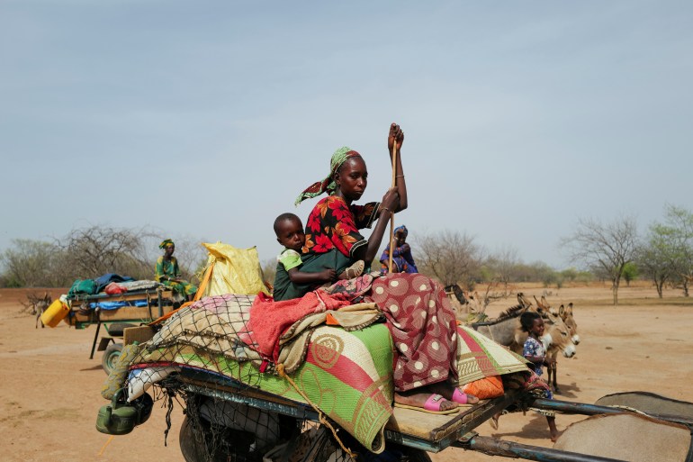 A Fulani nomadic tribe member sits on a cart as she travels in the Barkedji-Dodji Forest, in Linguere department, Louga region, Senegal, July 14, 2021