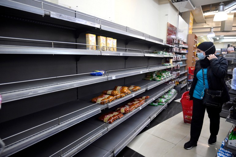 A customer walks past an almost empty shelf in a supermarket in Beirut, Lebanon, 24 March 2021.