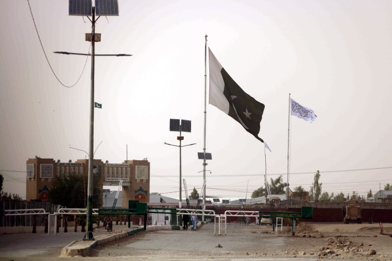 A Taliban flag, iin white, raised at the Afghan side of the Pakistan-Afghanistan border at Chaman, Pakistan [File: Akhter Gulfam/EPA]