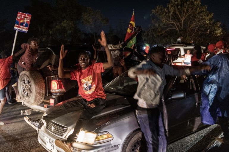 Supporters celebrate in front of the home of Hakainde Hichilema, declared the winner of Zambia's elections [Marco Longari/AFP]