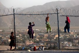 Afghan children climb onto a fence while playing, as they sell tea in Kabul on September 4, 2013 [File: Reuters/Mohammad Ismail]