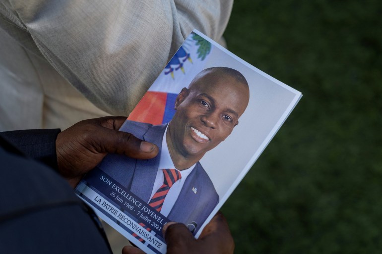 A person holds a photo of late Haitian President Jovenel Moise