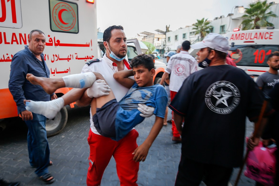 A wounded Palestinian child is taken to hospital after taking part in the protest at the Israel-Gaza fence. A 13-year-old Palestinian boy was shot in the head, health officials said. [Mohammed Salem/Reuters]