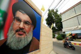 A man rides a motorbike past a picture of Lebanon's Hezbollah leader Sayyed Hassan Nasrallah, near Sidon, Lebanon