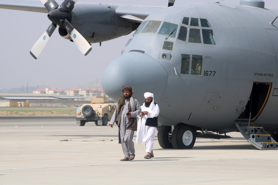 Taliban kráčí před vojenským letadlem den poté, co se americké jednotky stáhly z mezinárodního letiště Hamid Karzai v Kábulu.  [Reuters]