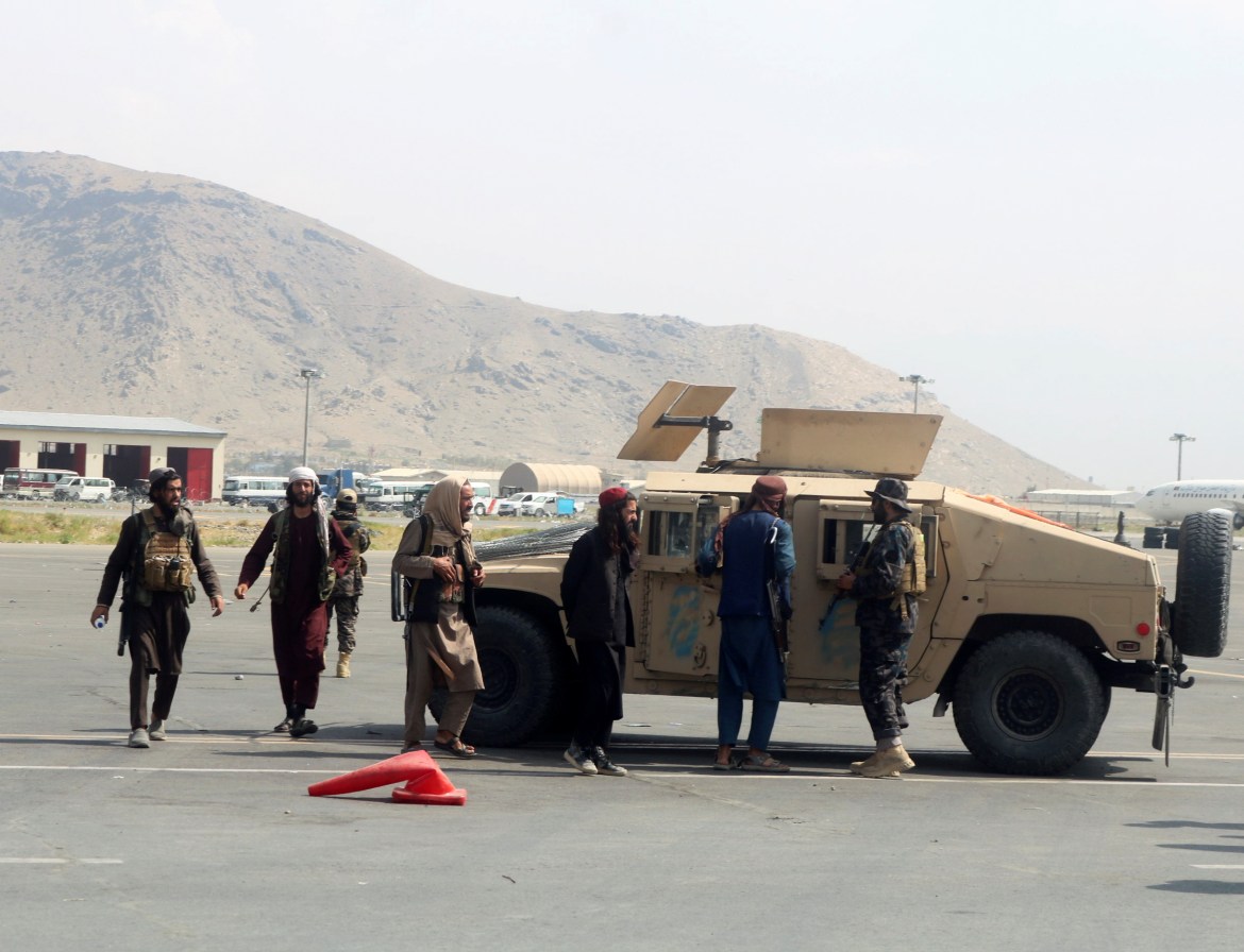 Síly Talibanu hlídkují na přistávací dráze na mezinárodním letišti Hamíd Karzáí.  [Reuters]