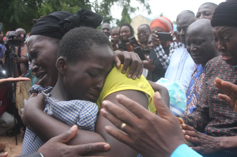 A mother hugs her daughter on July 25, 2021 after she was released together with other 27 students of the Bethel Baptist High School in Kadune state, Nigeria. Gunmen seized 121 students at the high school on July 5.