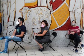 Three people are sitting in chairs waiting to be tested for COVID-19 in Mexico City
