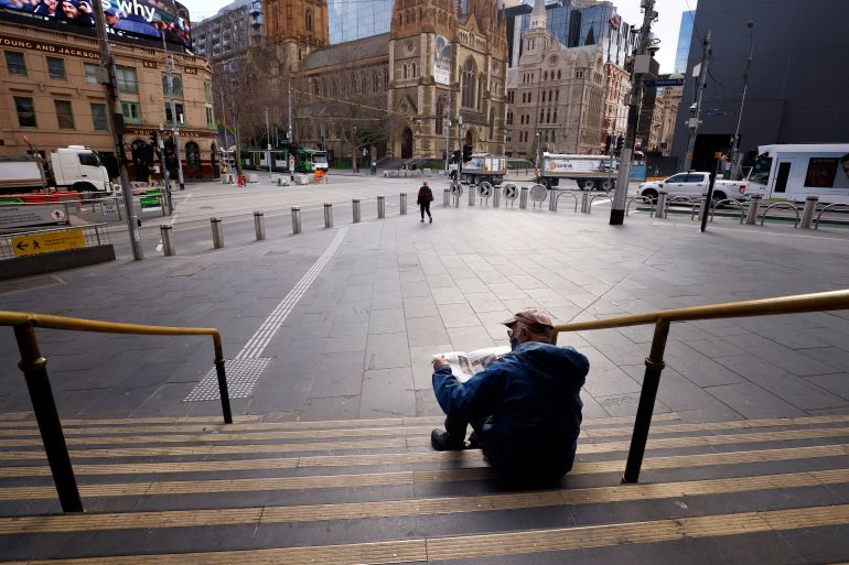 Man sits outside Flinders Station, Melbourne