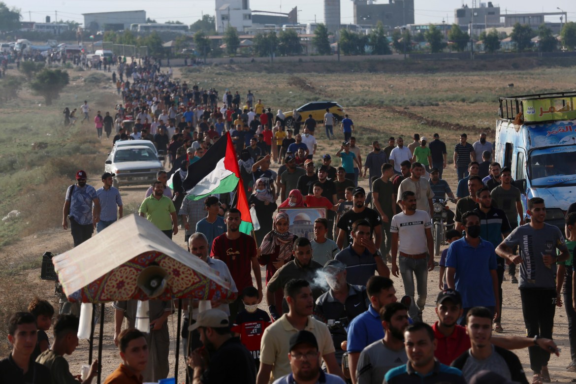 Demonstrators march towards the Gaza Strip's fence with Israel. [Adel Hana/AP Photo]